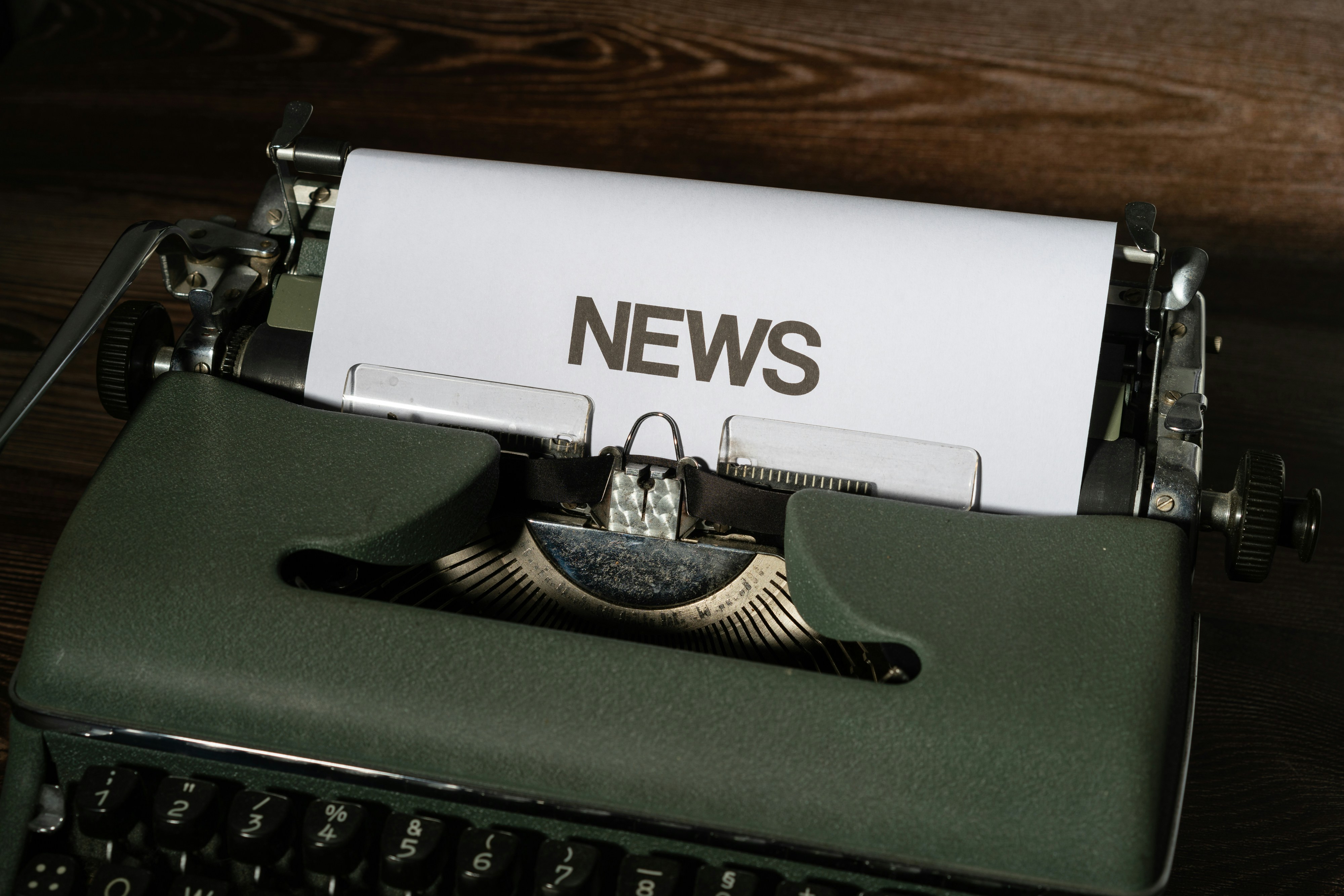 A close-up of a typewriter with newspaper on it